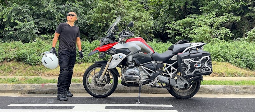 Daniel Tan standing beside his motorcycle