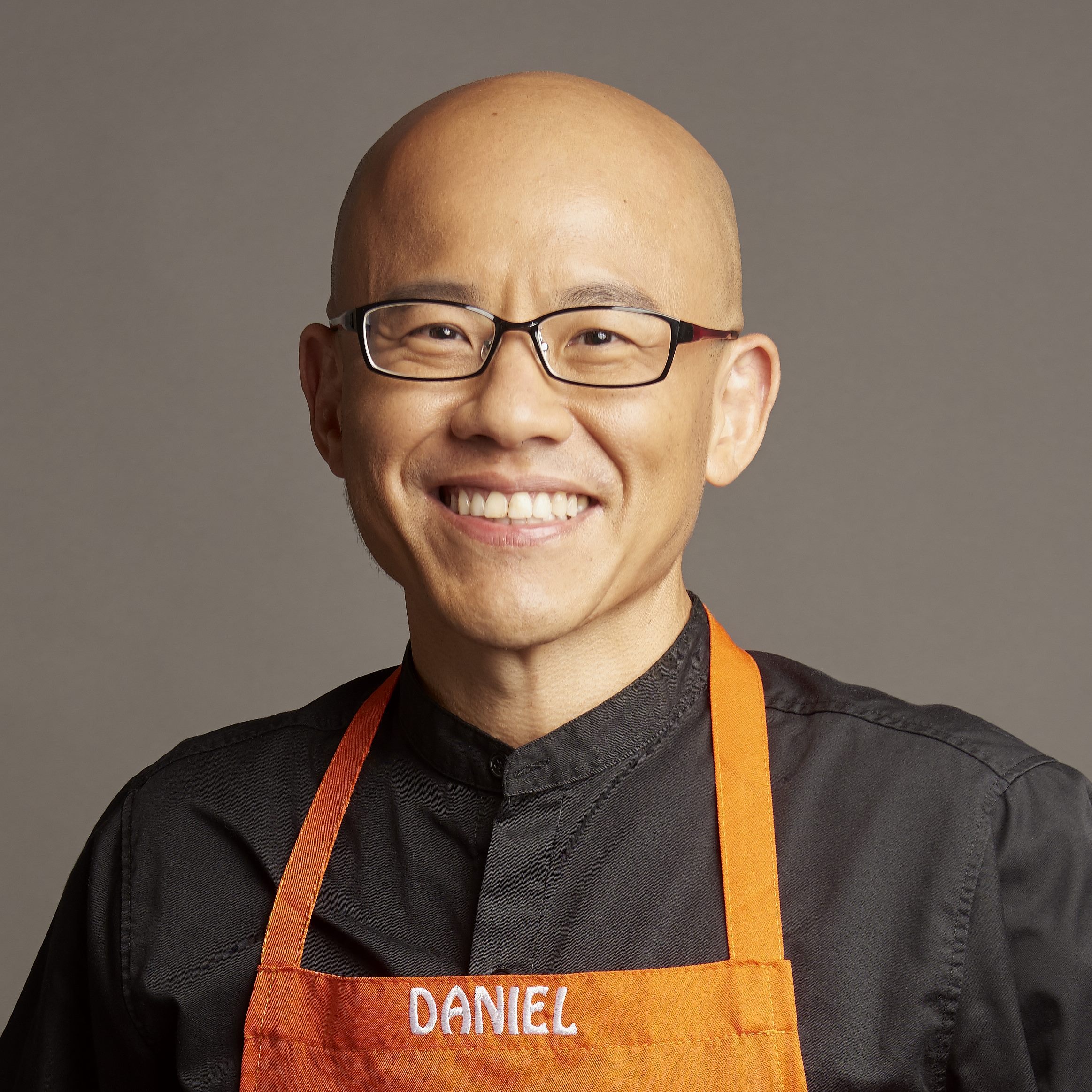 Daniel Tan smiling in a Food Playground apron