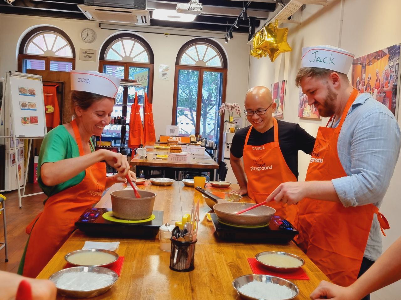 Daniel Tan smiling while participants cook in a Food Playground studio