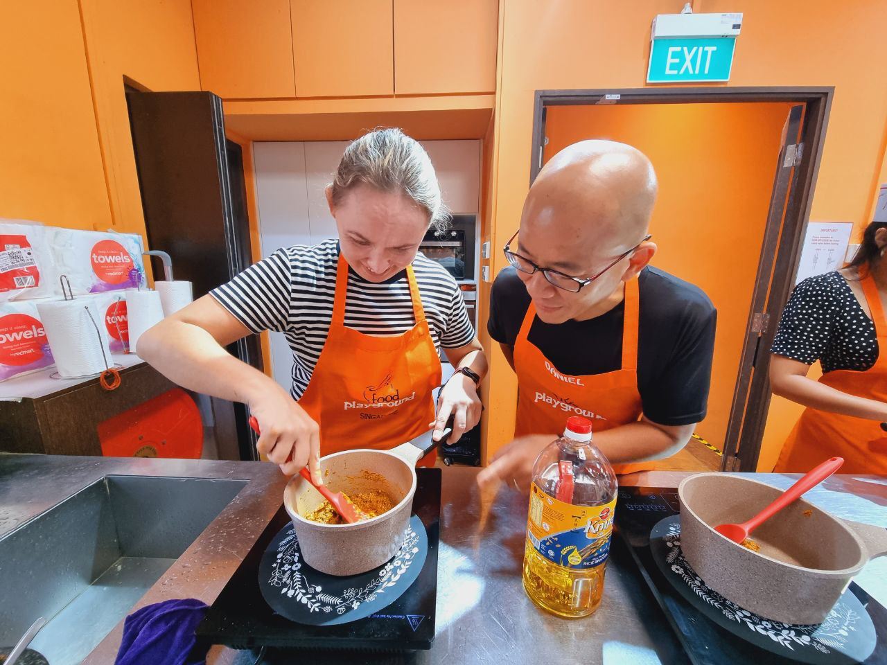 Daniel Tan guiding a participant during a hands-on cooking class
